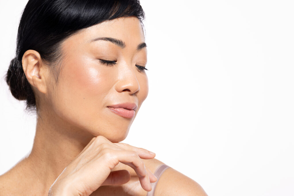 Beautiful mature Japanese woman posing against a white background